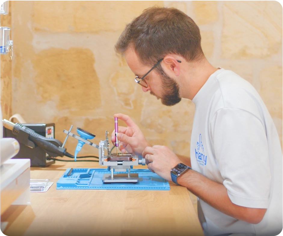 mikael le fondateur de handy en train de réparer un smartphone et ordinateur