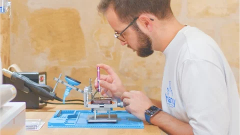 mikael le fondateur de handy en train de réparer un smartphone et ordinateur
